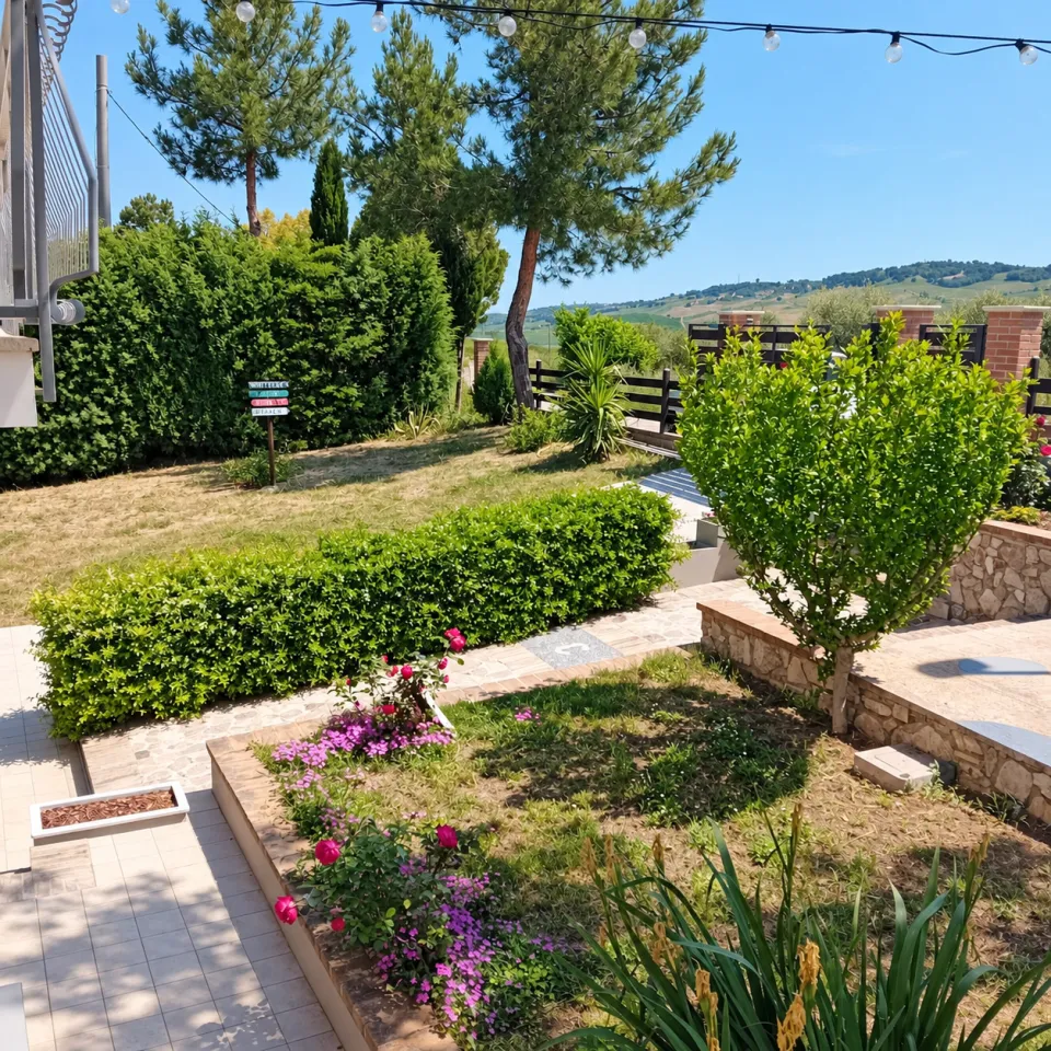Il giardino recintato di Villa Nonno Nicola, con il prato e le colline